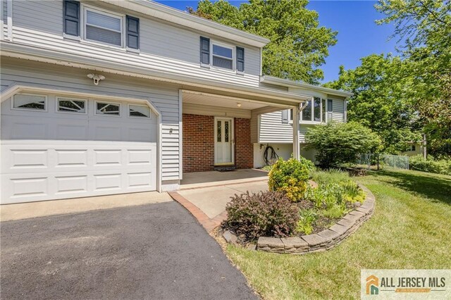 3 Revock Rd, East Brunswick, NJ 08816 - view of front of home featuring an attached garage, a front lawn, driveway, and brick siding