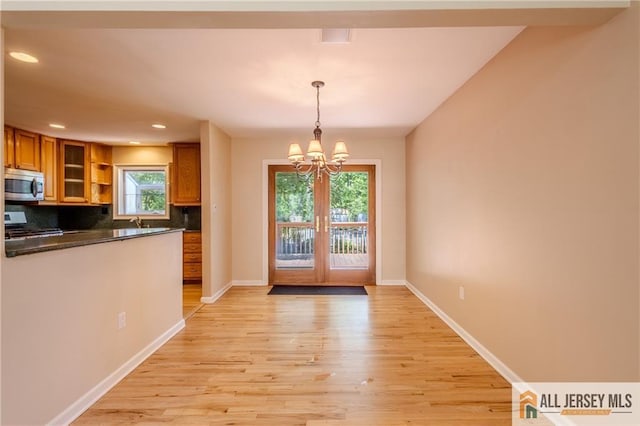 3 Revock Rd, East Brunswick, NJ 08816 - kitchen with stainless steel appliances, brown cabinets, dark countertops, a chandelier, and light wood finished floors