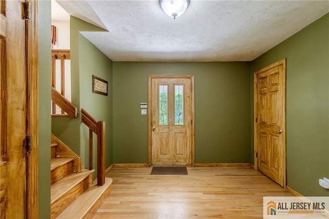3 Revock Rd, East Brunswick, NJ 08816 - foyer with light wood-style flooring, baseboards, and stairs