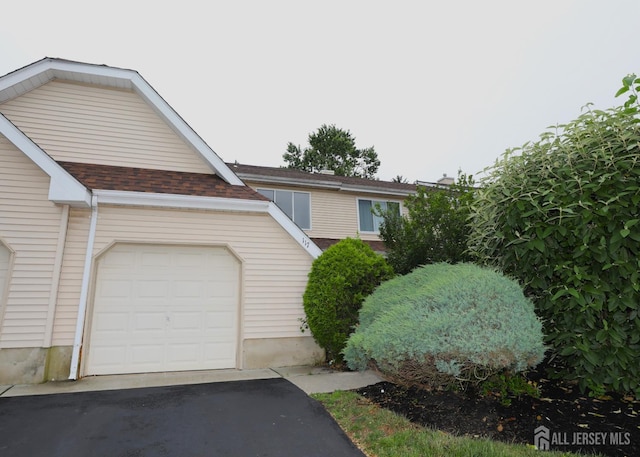 117 Nathan Dr, North Brunswick, NJ 08902 - view of front facade with roof with shingles, an attached garage, and asphalt driveway