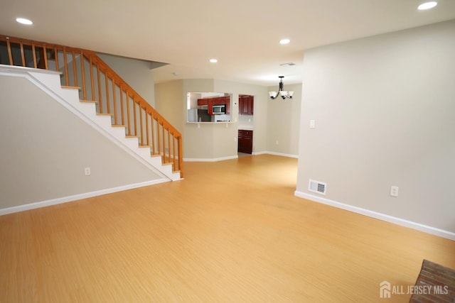 117 Nathan Dr, North Brunswick, NJ 08902 - unfurnished living room with a chandelier, recessed lighting, light wood-style floors, and stairway