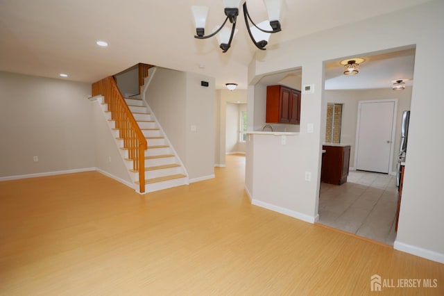 117 Nathan Dr, North Brunswick, NJ 08902 - unfurnished living room with light wood finished floors, stairway, a chandelier, and recessed lighting
