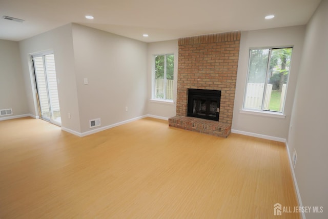117 Nathan Dr, North Brunswick, NJ 08902 - unfurnished living room featuring light wood-type flooring, healthy amount of natural light, recessed lighting, and a fireplace
