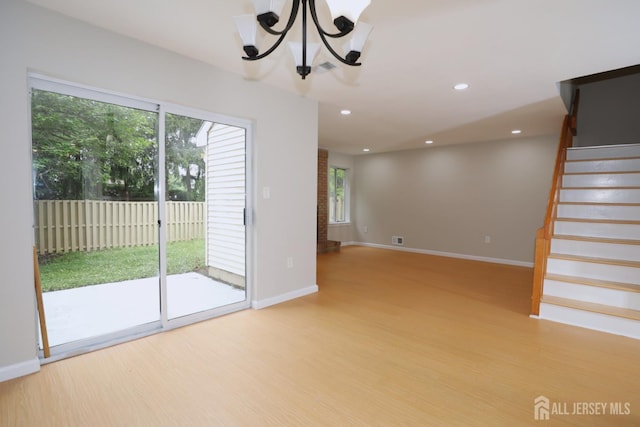 117 Nathan Dr, North Brunswick, NJ 08902 - unfurnished living room featuring a chandelier, wood finished floors, stairway, healthy amount of natural light, and recessed lighting