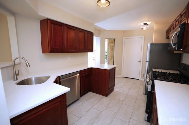 117 Nathan Dr, North Brunswick, NJ 08902 - kitchen with appliances with stainless steel finishes, a peninsula, dark brown cabinets, light countertops, and light tile patterned floors