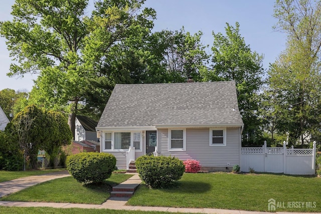 view of front facade with a shingled roof, a front lawn, fence, and crawl space
