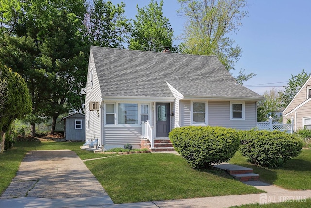 view of front of home featuring a chimney, a front yard, and a shingled roof