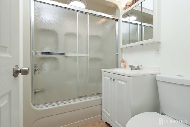 bathroom featuring toilet, enclosed tub / shower combo, and vanity