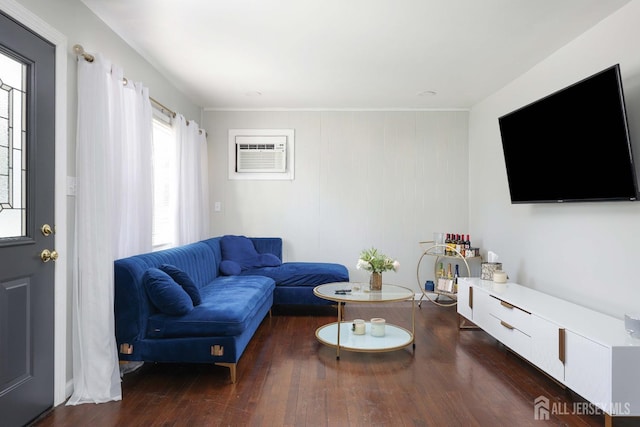 living area with an AC wall unit and wood finished floors