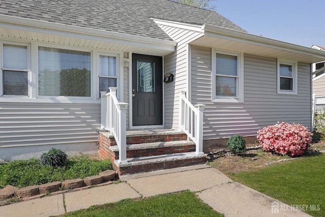 doorway to property featuring a shingled roof