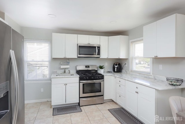 kitchen with white cabinetry, appliances with stainless steel finishes, and a sink