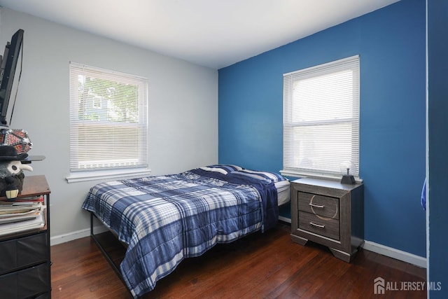 bedroom featuring baseboards and dark wood-style flooring