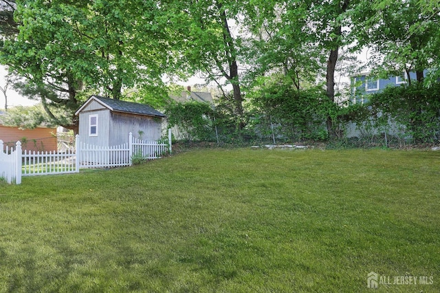view of yard featuring an outbuilding, a shed, and fence