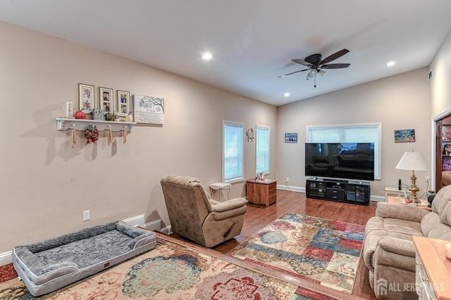 living room featuring hardwood / wood-style flooring, vaulted ceiling, and ceiling fan