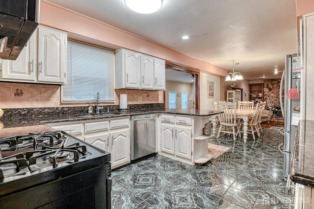 kitchen with appliances with stainless steel finishes, pendant lighting, white cabinets, and kitchen peninsula