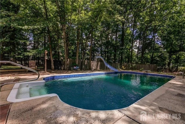 view of swimming pool featuring a patio area and a water slide