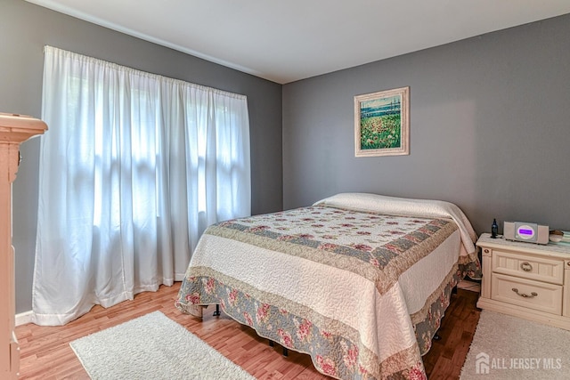 bedroom featuring multiple windows and light hardwood / wood-style floors