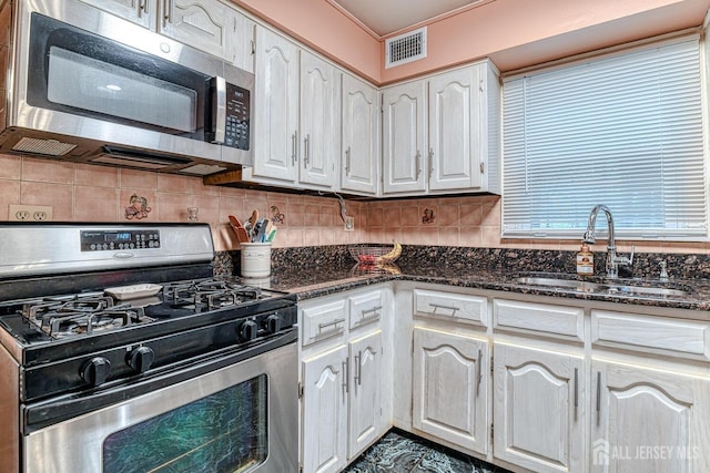 kitchen featuring dark stone countertops, sink, stainless steel appliances, and white cabinets