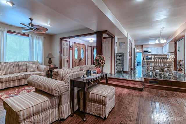 living room with wood-type flooring and ceiling fan with notable chandelier