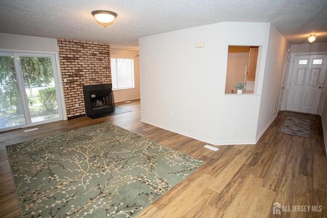 living room with wood finished floors, a textured ceiling, and baseboards