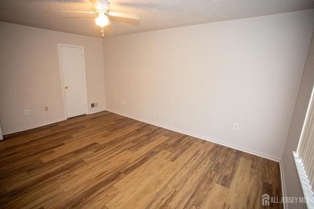 unfurnished room with wood finished floors, visible vents, baseboards, and ceiling fan