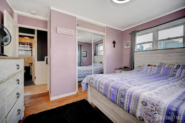 bedroom with light hardwood / wood-style flooring, a closet, and crown molding