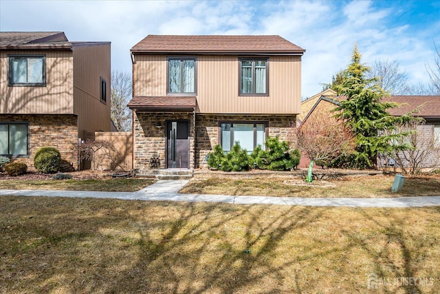 view of front of property featuring stone siding and a front lawn