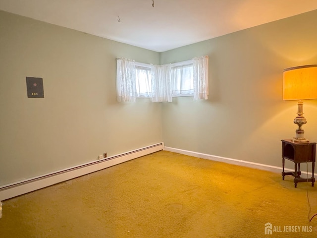 empty room featuring a baseboard heating unit, baseboards, and carpet flooring