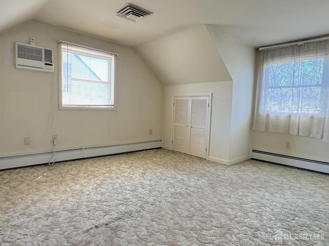 bonus room with vaulted ceiling, carpet, a wall unit AC, a baseboard heating unit, and baseboards