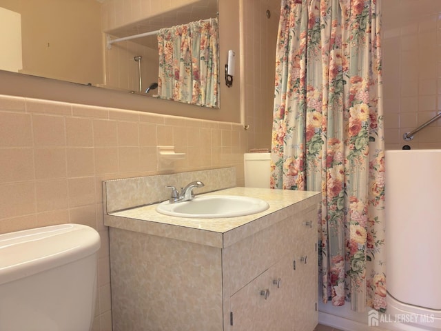 full bath featuring tile walls, vanity, toilet, and shower / tub combo with curtain