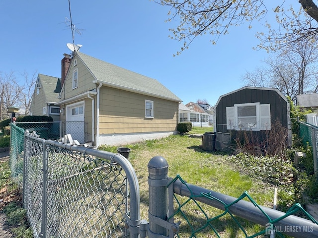 view of side of home with an outdoor structure, a chimney, and a storage unit