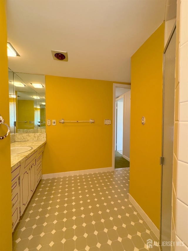 bathroom featuring baseboards, tile patterned floors, and vanity
