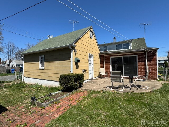 rear view of property featuring a patio and brick siding