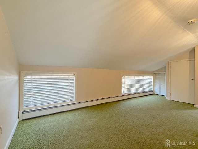 additional living space featuring baseboard heating, vaulted ceiling, carpet, and baseboards