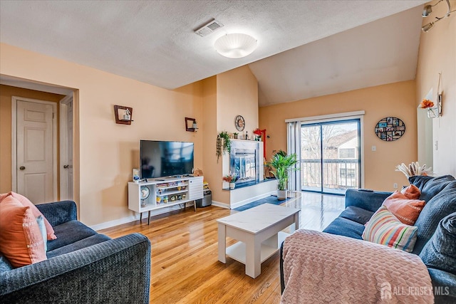121-F Beverly Hill Ter, Woodbridge Proper, NJ 07095 - living area with light wood-style floors, lofted ceiling, and a textured ceiling