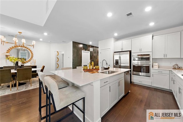 15 Galerie Ct, Monroe, NJ 08831 - kitchen with appliances with stainless steel finishes, recessed lighting, dark wood-style flooring, an island with sink, and white cabinets