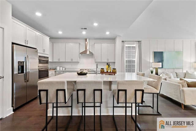 15 Galerie Ct, Monroe, NJ 08831 - kitchen with stainless steel appliances, wall chimney exhaust hood, a kitchen bar, white cabinets, and recessed lighting