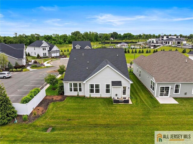 15 Galerie Ct, Monroe, NJ 08831 - back of property featuring a residential view, a lawn, a patio area, and roof with shingles