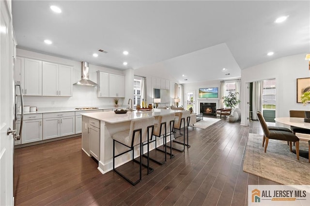 15 Galerie Ct, Monroe, NJ 08831 - kitchen with wall chimney exhaust hood, stainless steel appliances, a kitchen breakfast bar, open floor plan, and light countertops