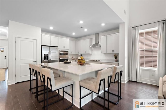 15 Galerie Ct, Monroe, NJ 08831 - kitchen featuring stainless steel appliances, wall chimney exhaust hood, dark wood-style floors, an island with sink, and recessed lighting