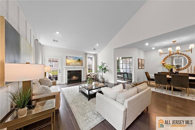 15 Galerie Ct, Monroe, NJ 08831 - living area with dark wood finished floors, recessed lighting, high vaulted ceiling, a lit fireplace, and a chandelier