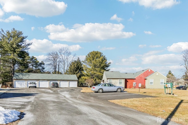 view of front of property featuring a front lawn, a garage, and an outbuilding