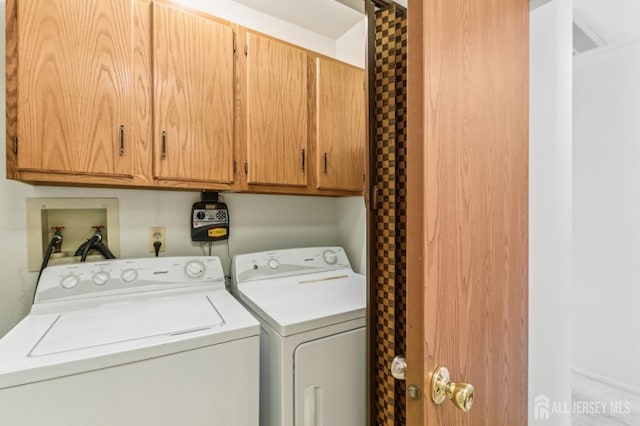 washroom with washing machine and dryer and cabinets