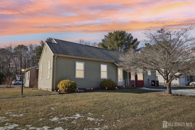 view of front of home featuring a yard and central air condition unit