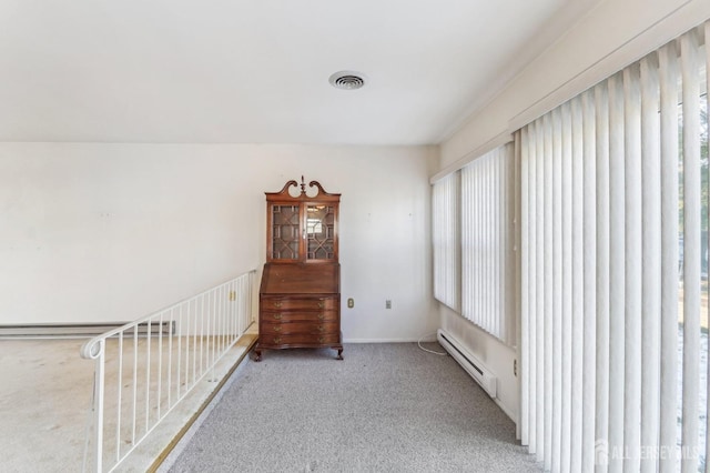 interior space with a baseboard heating unit and carpet floors