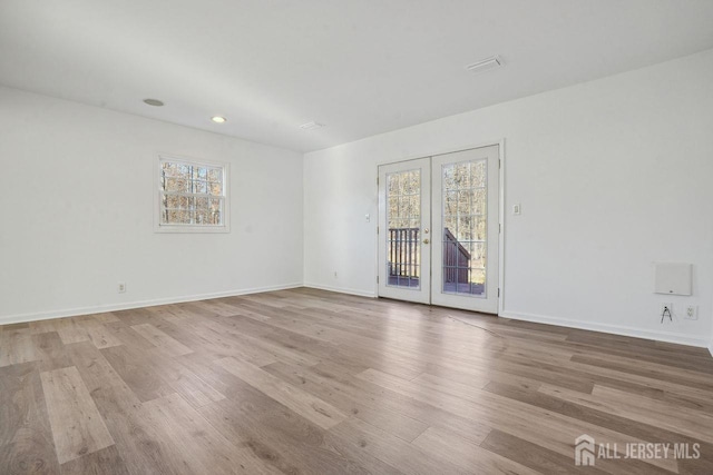 spare room with light wood-type flooring and french doors