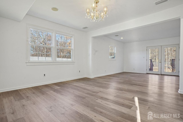 interior space with an inviting chandelier, plenty of natural light, and light hardwood / wood-style flooring