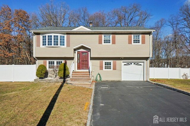 bi-level home with a front yard and a garage