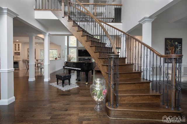 stairway with a towering ceiling and hardwood / wood-style flooring