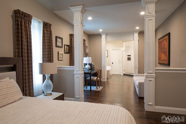 bedroom with dark hardwood / wood-style floors and decorative columns